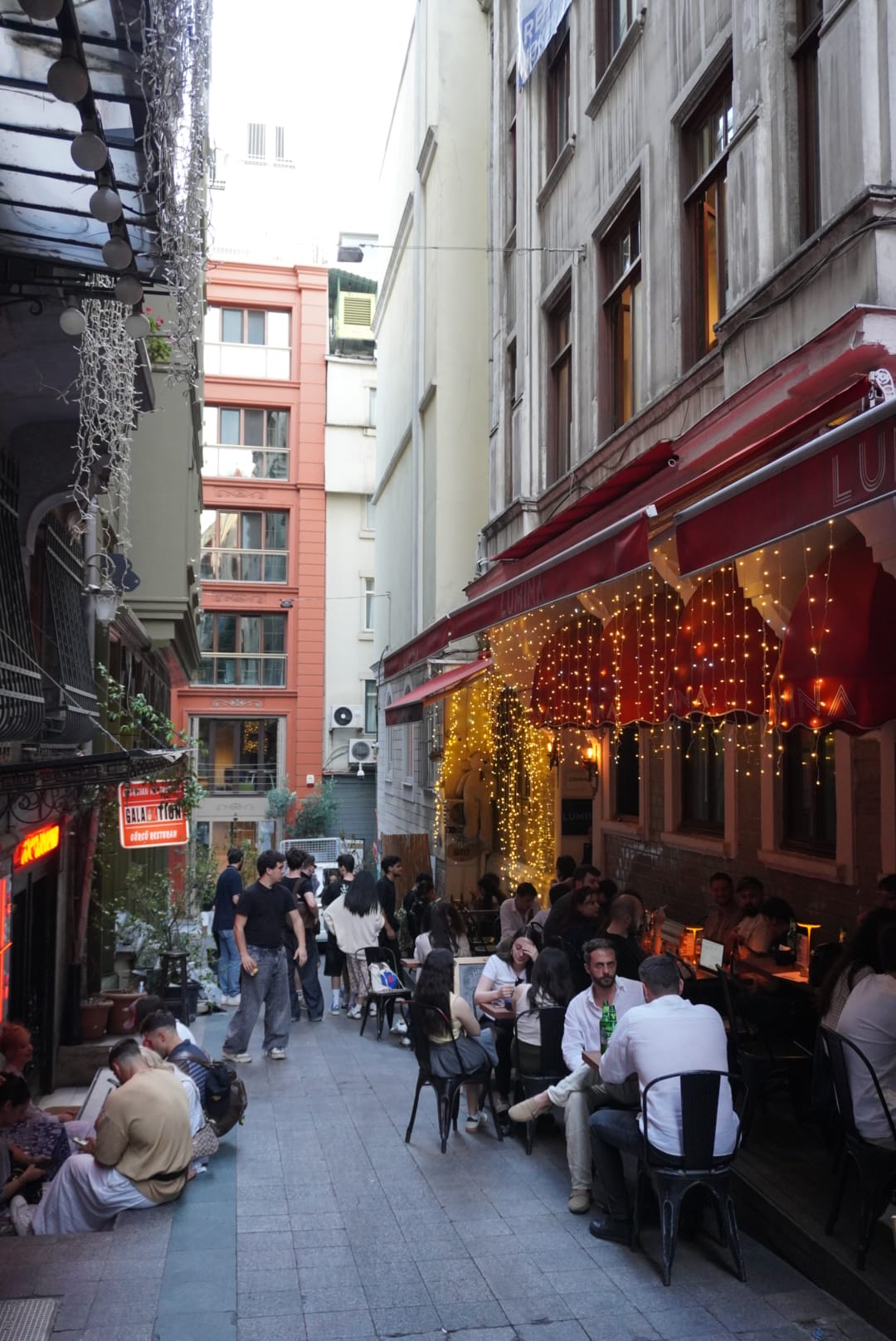Kalabalık sokak arasında dış servis alanı ve bar cephesi